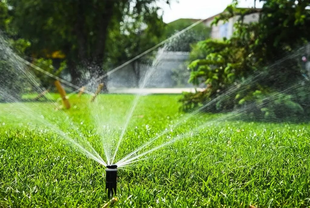 Irrigation installation in San Diego. Sprinklers showering a lawn with water.